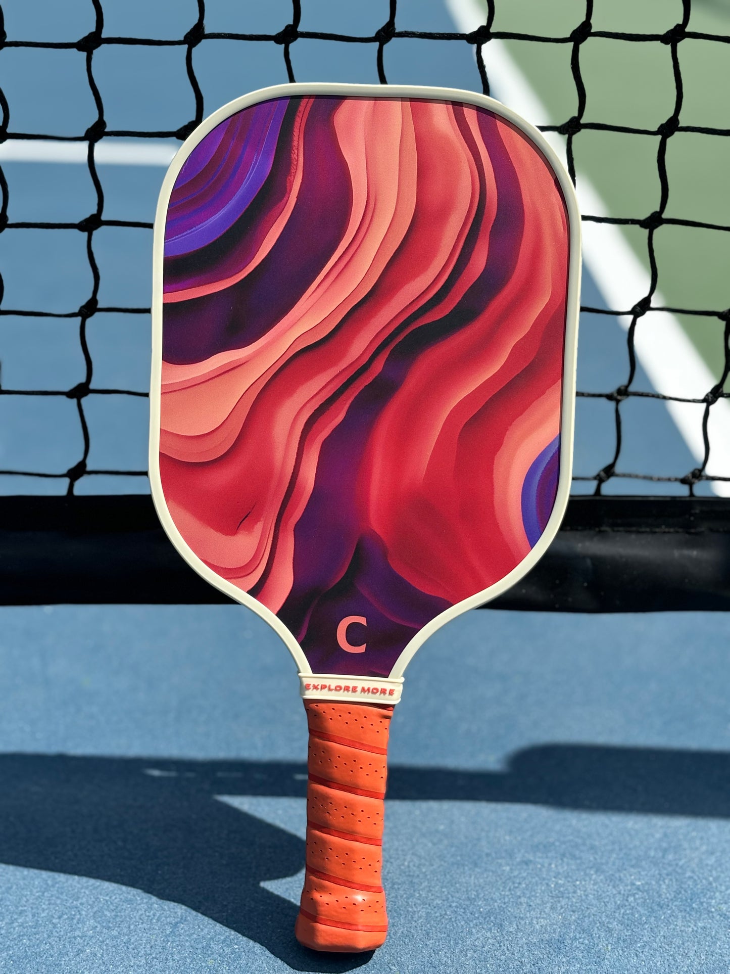 The Aurora Pickleball Paddle Against A Net