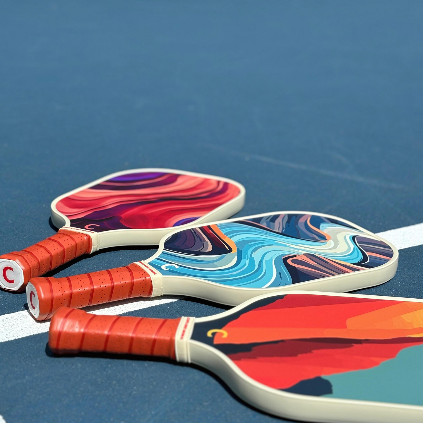 Three Canyon Pickleball Paddles On A Court