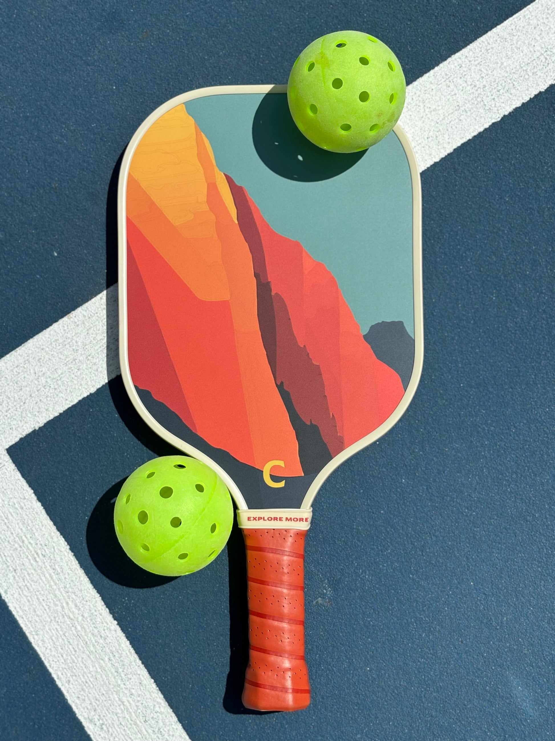 The Grand Pickleball Paddle Front With Two Balls 
