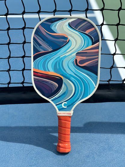 The River's Edge Pickleball Paddle Against A Net 