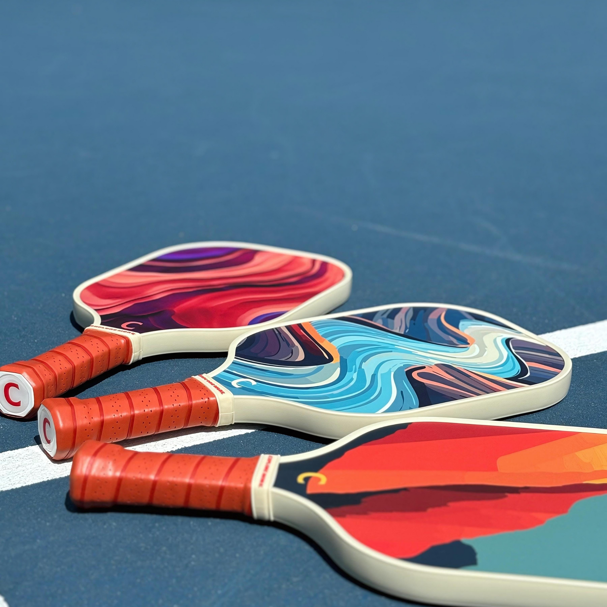 Three Canyon Pickleball Paddles On A Court 